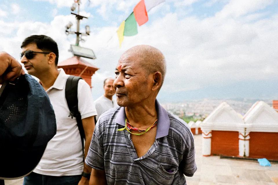 Nepali men at the Swayambhunath viewpoint with the Kathmandu valley behind them