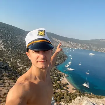 Selfie in a captain hat high above a bay full of anchored boats on the SYB Greece trip