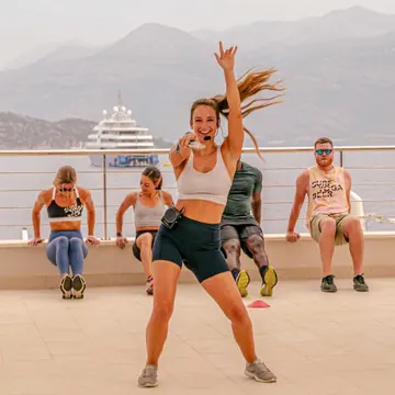 Instructor leading an outdoor workout on a seaside terrace on the SYB Croatia trip