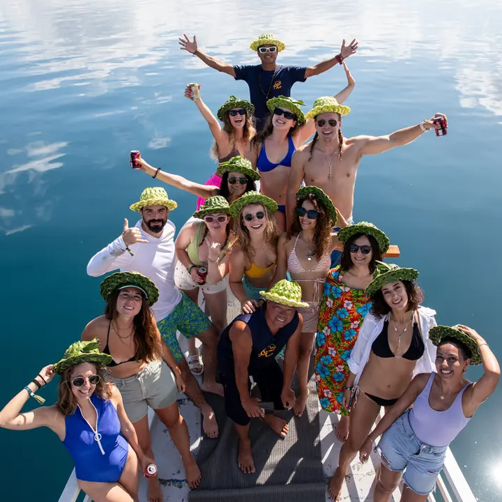 The crew in matching hats cheering on the bow of the boat, seen from above, on the SYB Philippines trip