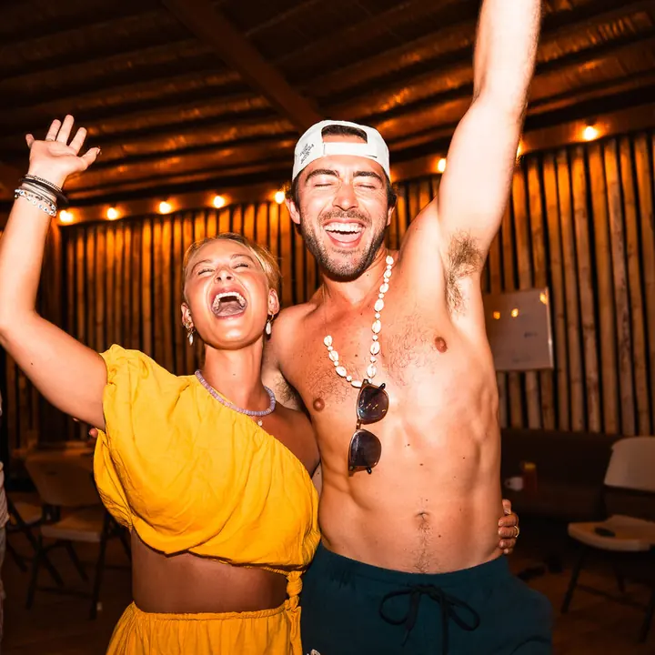 Two friends cheering at the villa party