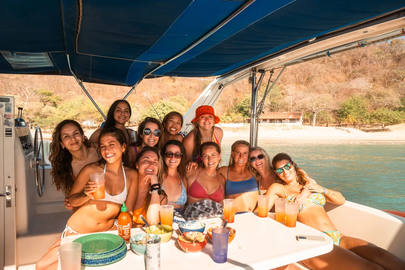 SYB travelers smiling around a table of food and drinks on the deck of a catamaran in Nicaragua