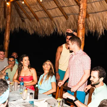 Group dinner at a long table under a thatched roof on the SYB Nicaragua Surf Camp trip