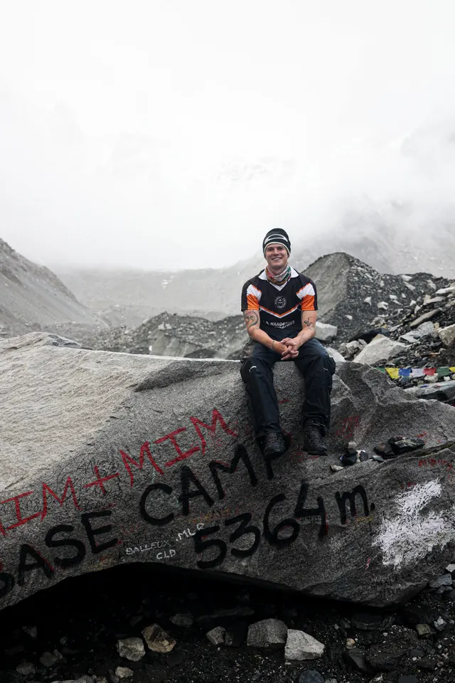 A trekker sitting alone on the painted Everest Base Camp 5,364 m rock