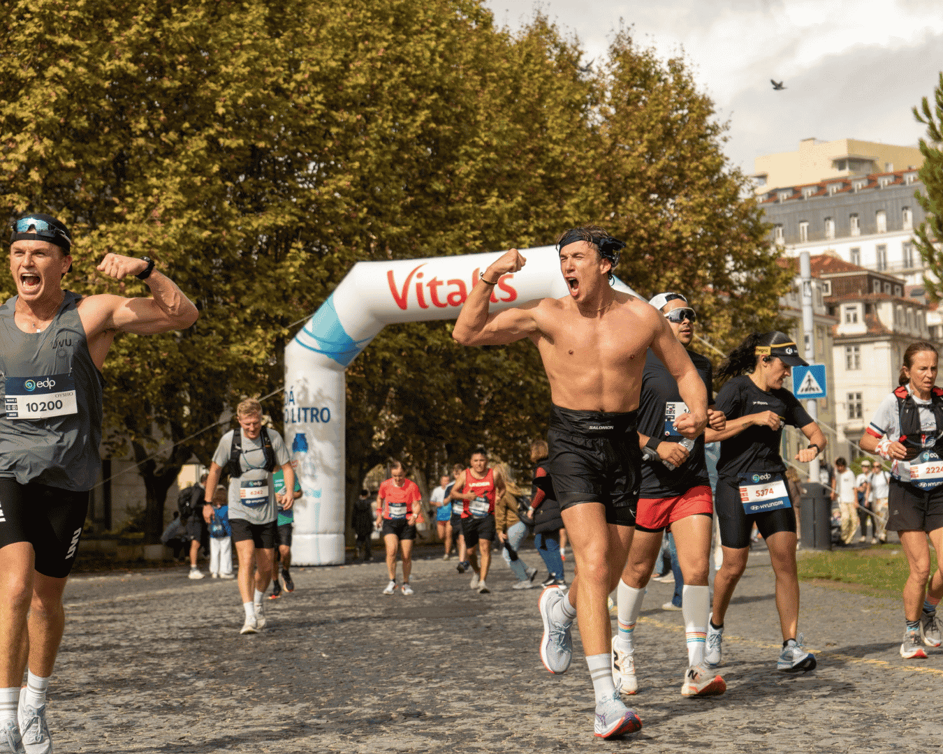 Shirtless runner cheering as he makes it to halfway through the Athens Marathon with Hardest Adventures.
