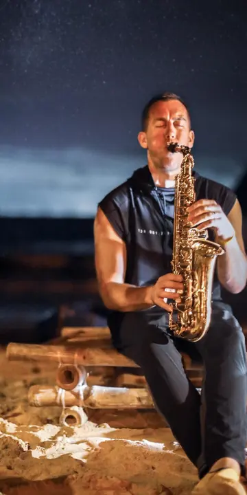 Saxophone player on the beach under the night sky on the SYB Philippines trip