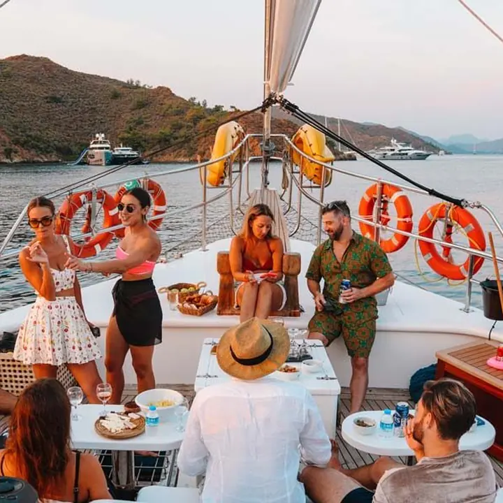 Crew sharing drinks and snacks on the bow of the gulet at golden hour on the SYB Turkey trip
