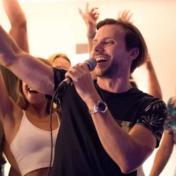 Singing into the mic with friends laughing on a night out on the SYB Croatia trip