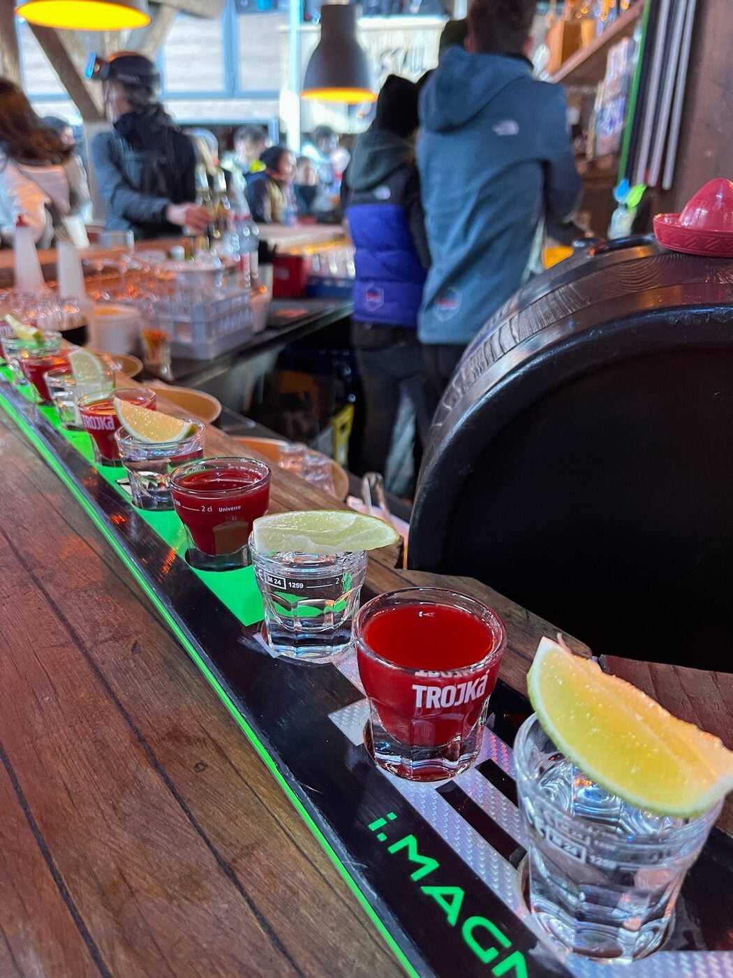 SurfYogaBeer crew doing a shot ski at a Zermatt bar