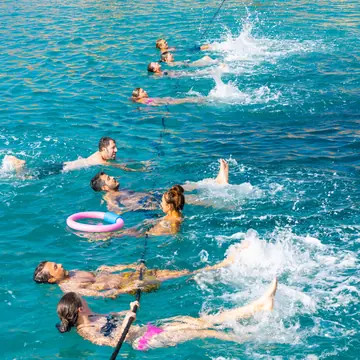 Group swimming with floats in turquoise water on the SYB Turkey trip