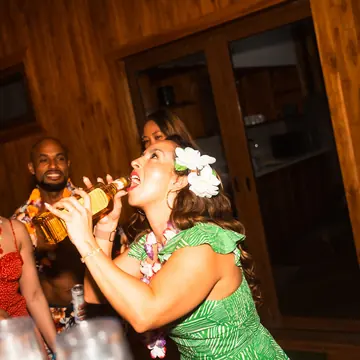 Friends in leis and flower crowns sharing drinks on theme night on the SYB Nicaragua trip