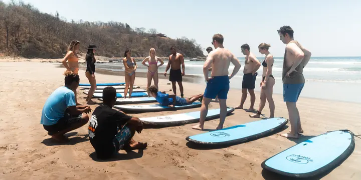 Surf lesson briefing on the sand with boards lined up on the SYB Nicaragua Surf Camp trip