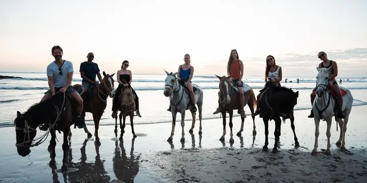 Group horseback ride lined up along the shoreline on the SYB Nicaragua trip