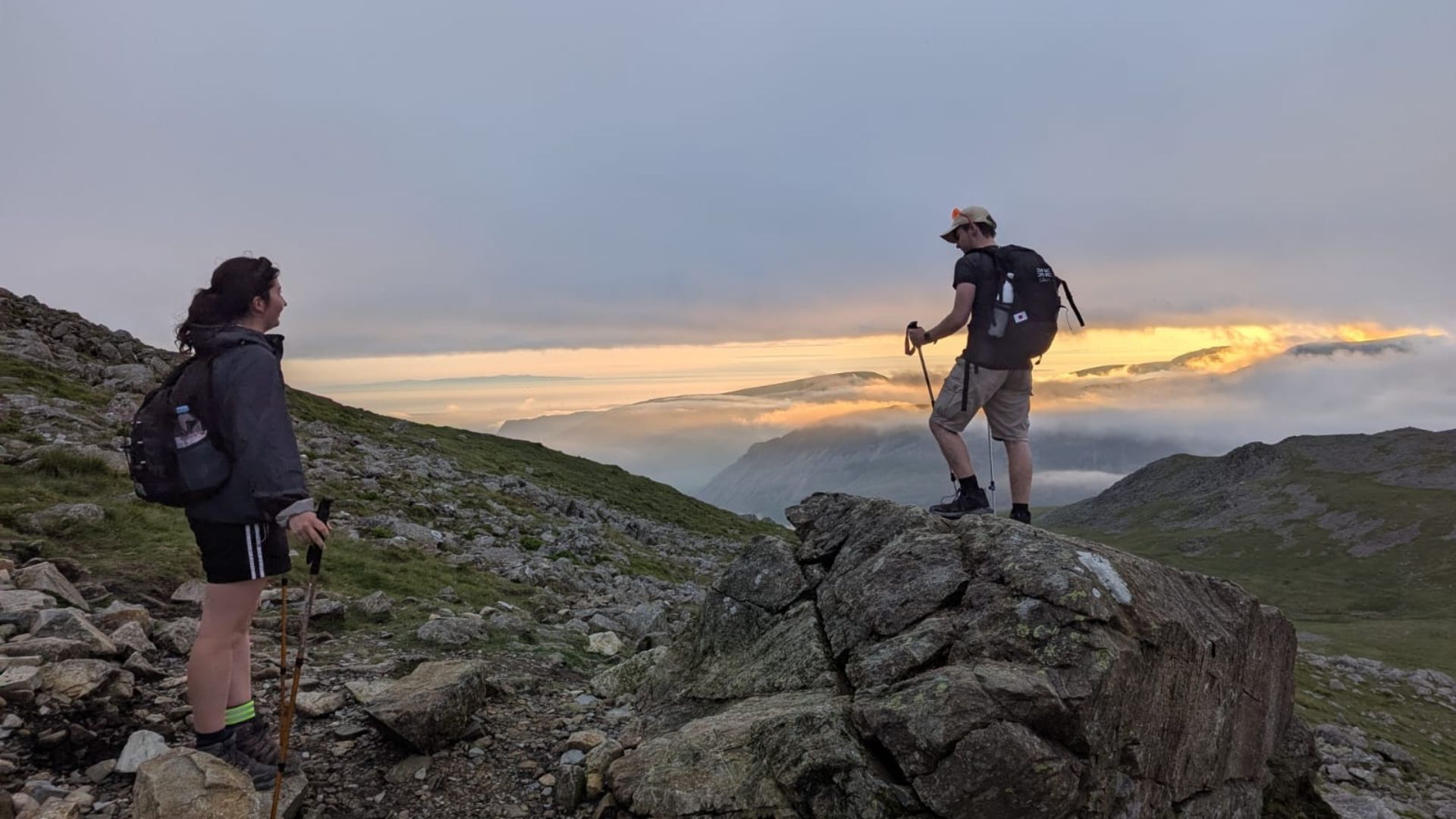 Group of university students hiking up Scafell as the sun sets during their Hardest Adventures national three peaks challenge for charity.