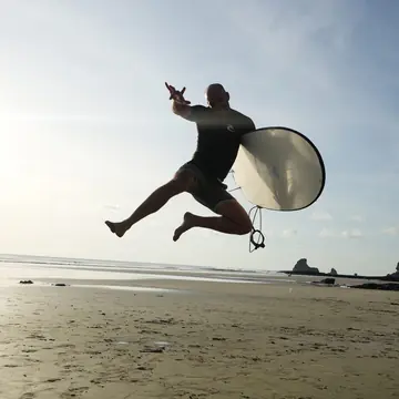 Jumping in the air with a surfboard on the beach on the SYB Nicaragua Surf Camp trip