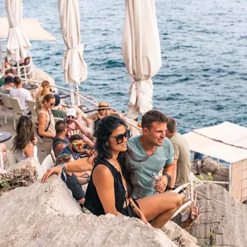 Friends at a bar built into the rocks above the sea on the SYB Croatia trip