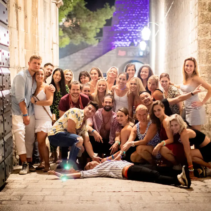 The whole crew posing in an old stone doorway at night on the SYB Croatia trip