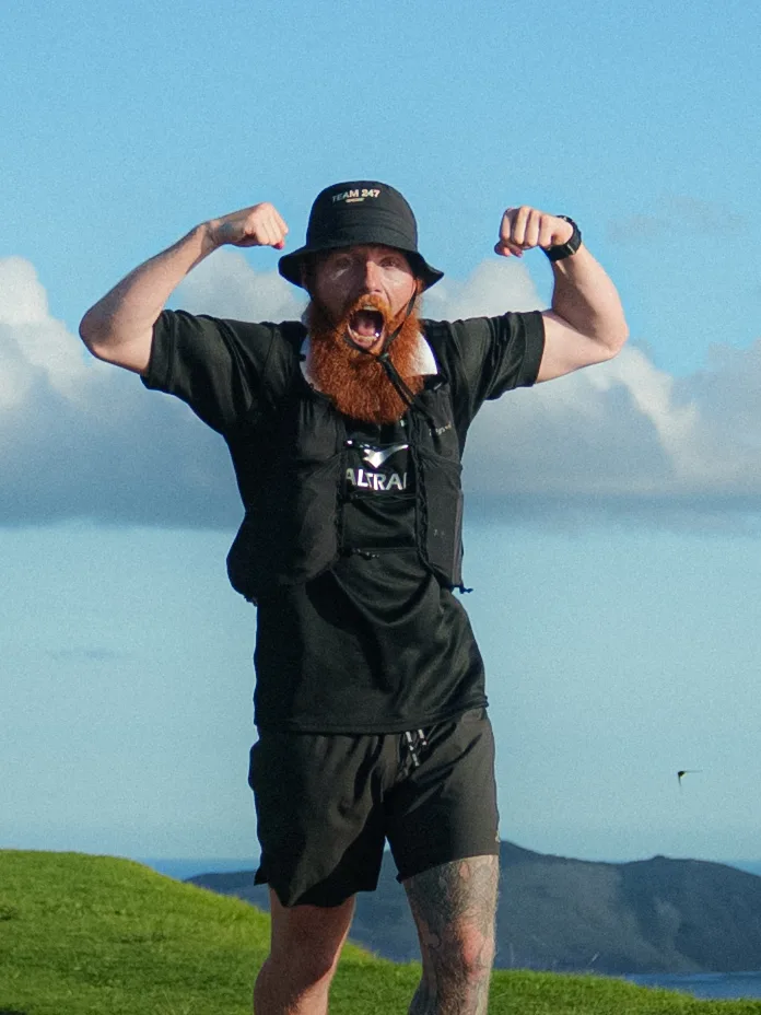 Russ Cook, Hardest Adventures co-founder, celebrating with both arms flexed ahead of the Barcelona Marathon trip