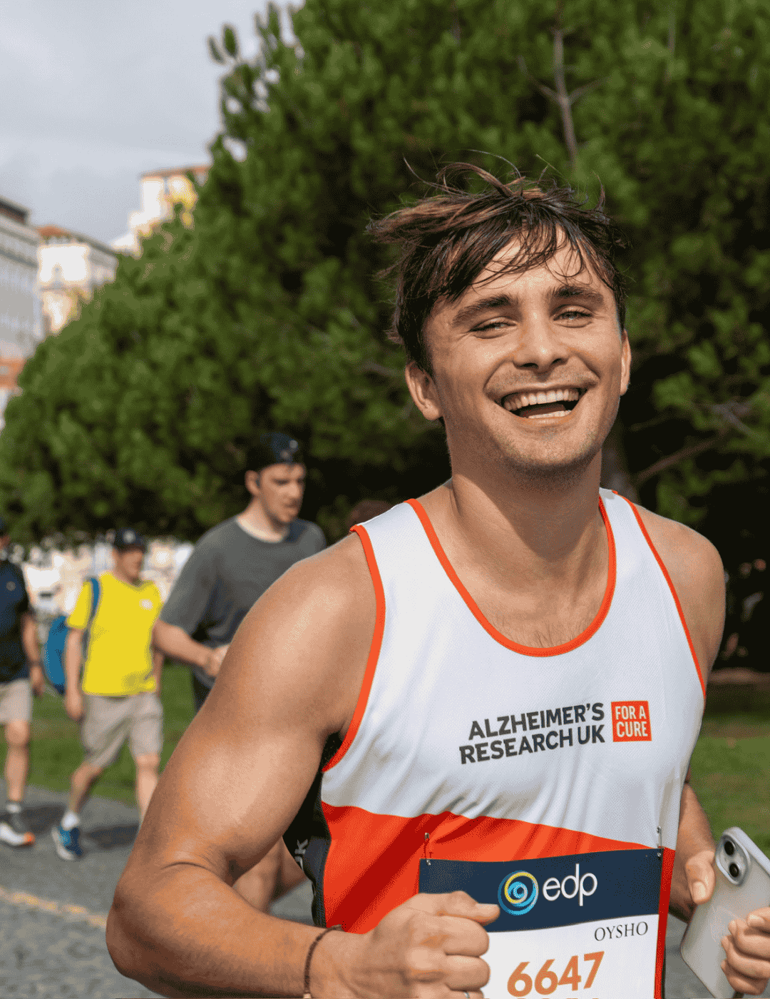 Runner smiling during the Lisbon Marathon as he runs for the charity Alzheimer's Research UK.