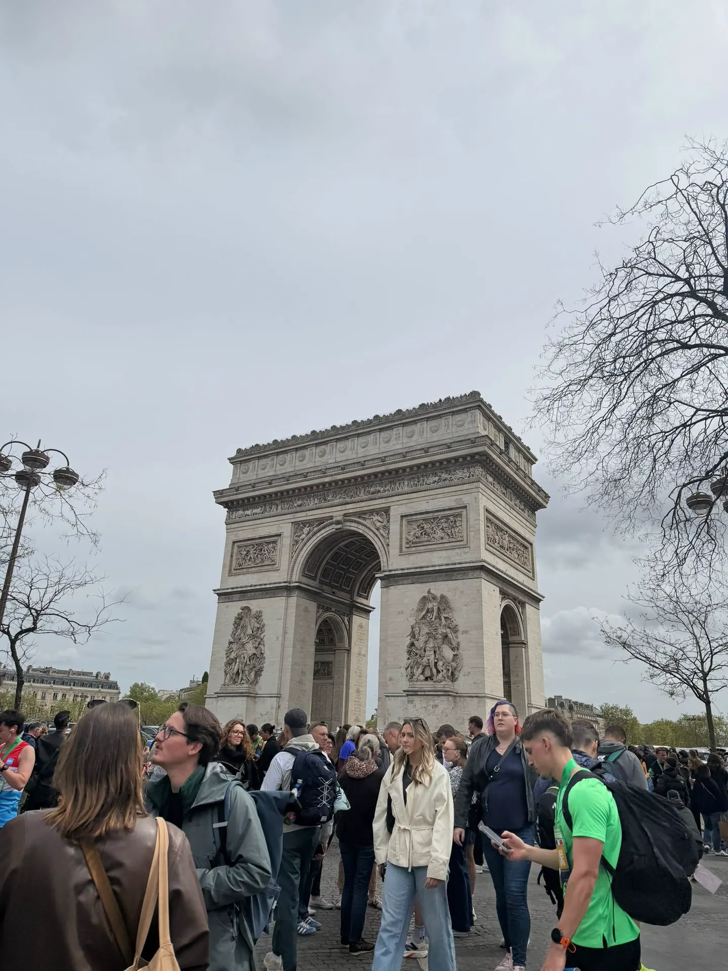 Runners passing the Arc de Triomphe during the Paris Marathon with Hardest Adventures.