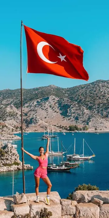 Posing under a Turkish flag on a hilltop above a bay full of boats on the SYB Turkey trip