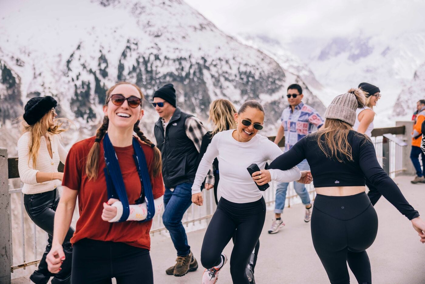 SYB travelers dancing on a snowy terrace after a ski day