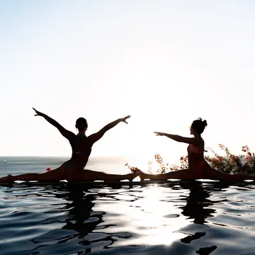 Two yoga silhouettes on the edge of the infinity pool above the ocean on the SYB Nicaragua trip