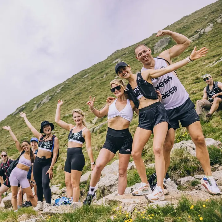 Hiking crew striking poses on a grassy mountain slope on the SYB Dolomites trip