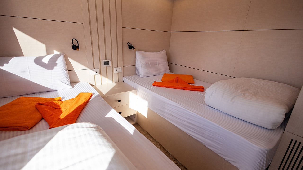A shared upper deck cabin with two separate beds