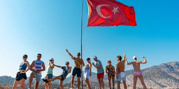 Group flexing under a Turkish flag at the top of a hike on the SYB Turkey trip