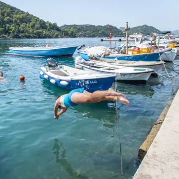 Diving off the harbour wall next to small boats on the SYB Croatia trip