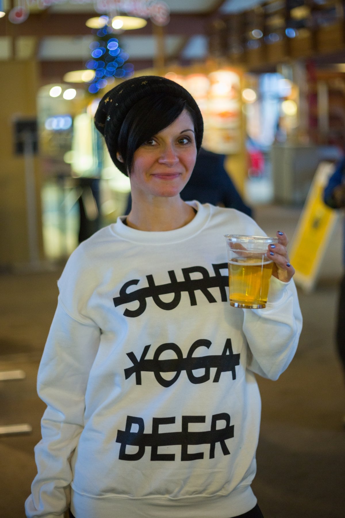 SYB crew member at apres in Vermont holding a beer, wearing the white cross-out crewneck