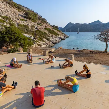 Group workout on a seaside terrace with the gulet anchored behind on the SYB Turkey trip