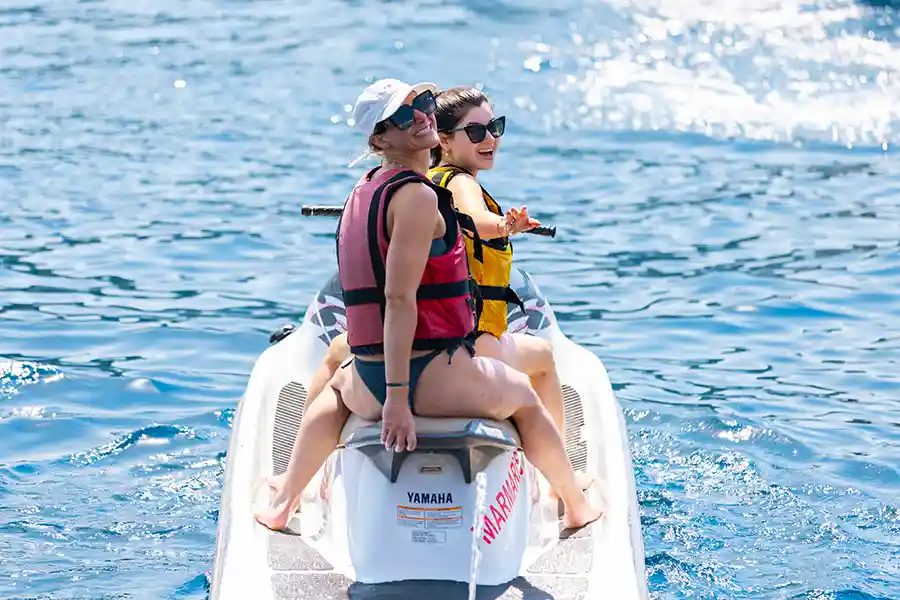 SurfYogaBeer guests on a jet ski in a Turkish Riviera bay