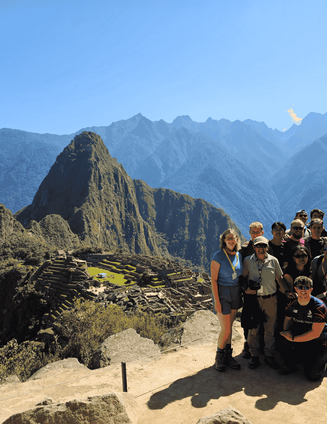 Group of university students celebrating with clear skies during August, the best time of the year at Machu Picchu.
