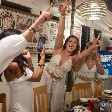 Friends dressed in white cheering at dinner on a night out on the SYB Philippines trip