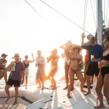 Crew dancing on the catamaran at golden hour on the SYB Nicaragua Surf Camp trip