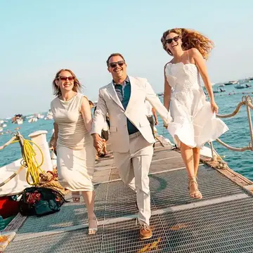 Three friends in white running down the dock on the SYB Amalfi Coast trip