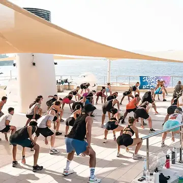 Big group workout under shade sails by the sea on the SYB Croatia trip