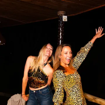 Two friends in animal print dancing at night on the SYB Kenya trip