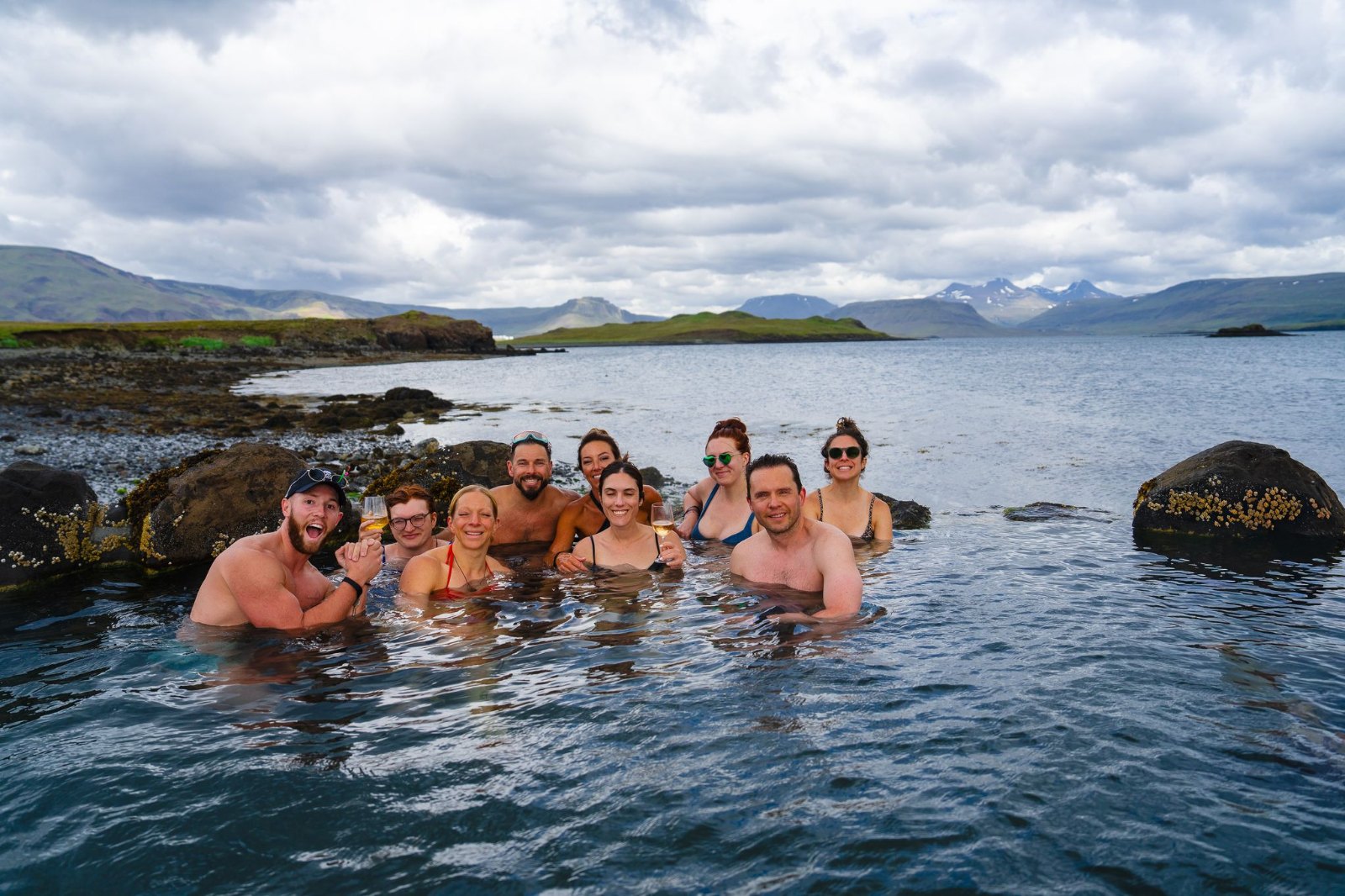 The SurfYogaBeer crew soaking in a hot spring by the water
