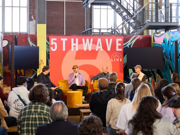An audience listens to a panel talk on the 5THWAVE stage