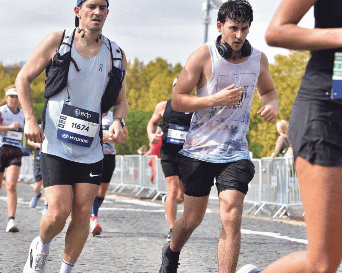 Two runners side-by-side almost finishing the Athens marathon with Hardest Adventures.