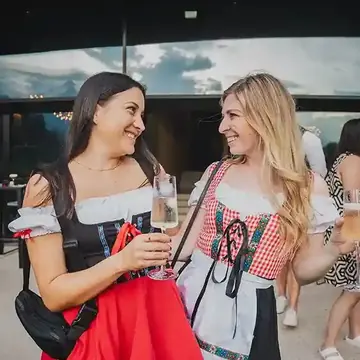 Two friends laughing in dirndls on dress up night on the SYB Dolomites trip