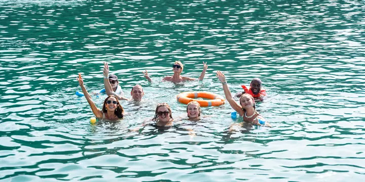 Group swimming and waving in a turquoise bay on the SYB Nicaragua trip