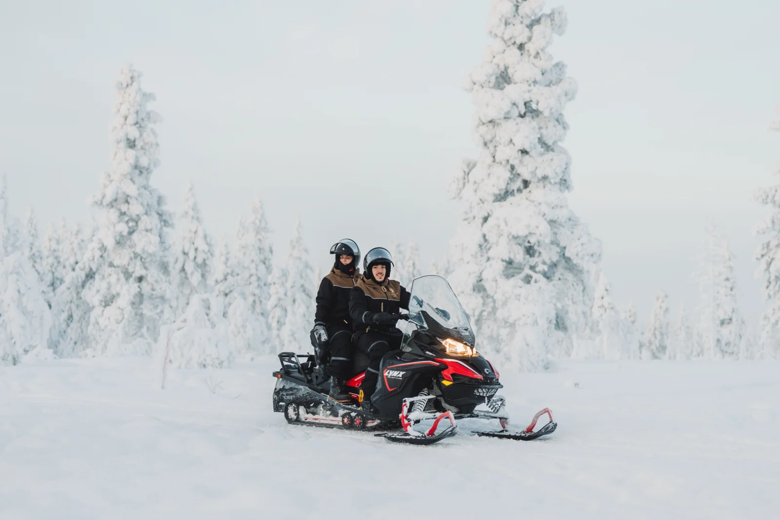 Snowmobiling through pine forest