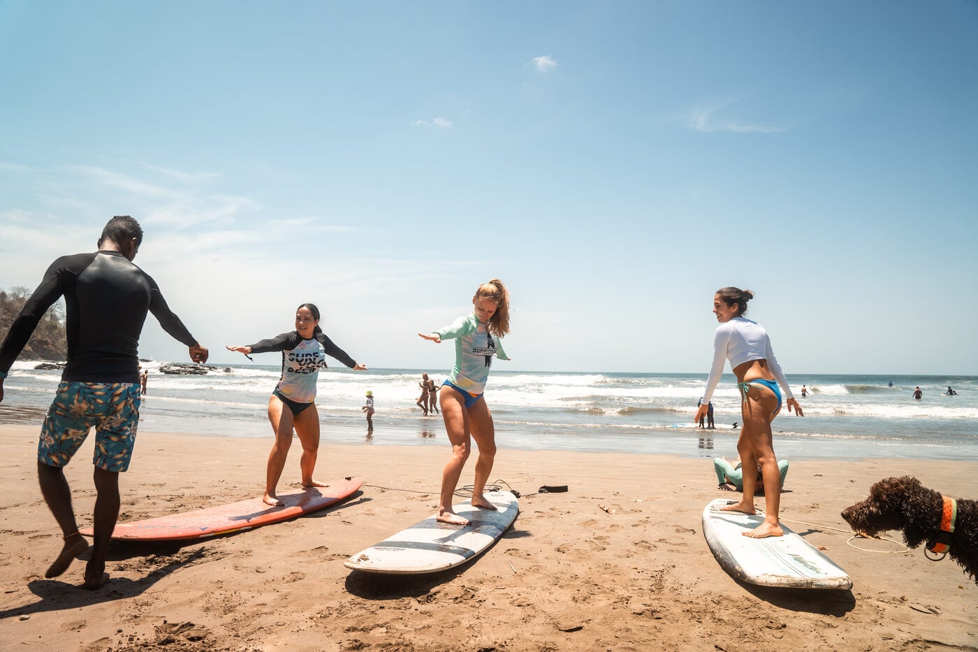 Surfers walking down the sand toward the beach break at Playa Maderas, Nicaragua