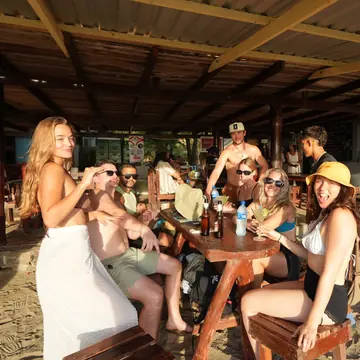 Crew around a table at a beach bar on the SYB Nicaragua Surf Camp trip