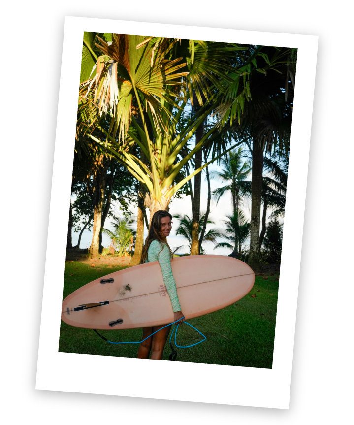 Surfer with a pink board under palms