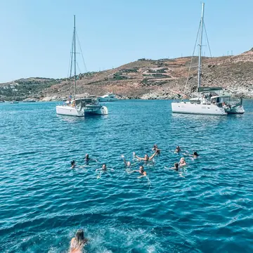 The crew swimming in a bay between anchored sailboats on the SYB Greece trip